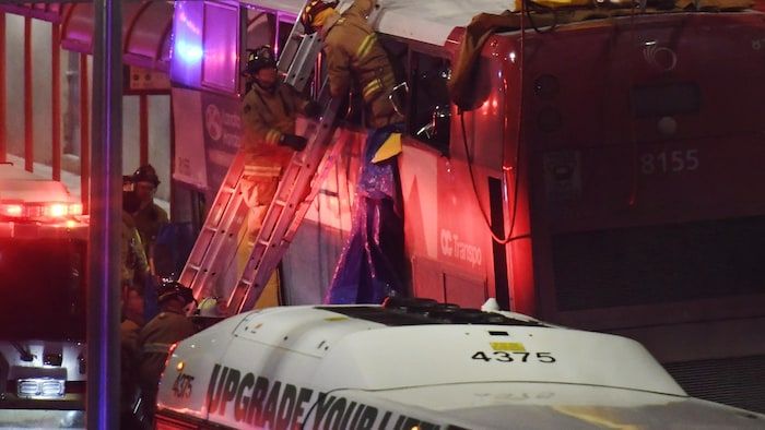 Les premiers intervenants travaillent sur les lieux d'un accident impliquant un bus de deux niveaux qui a frappé une absence d'étouffement à Ottawa. Canadian Press.
