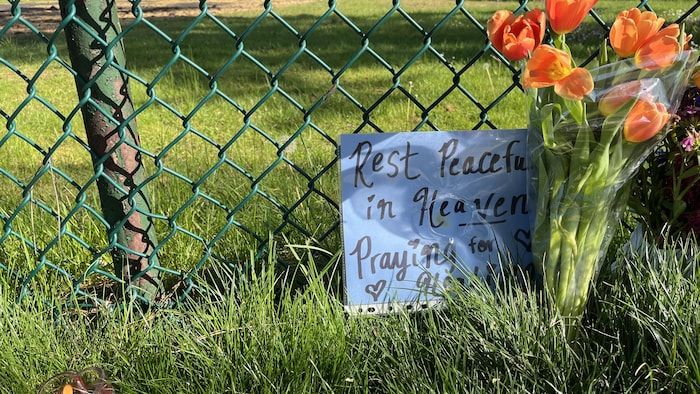 Un message de condoléances et un bouquet de fleurs.