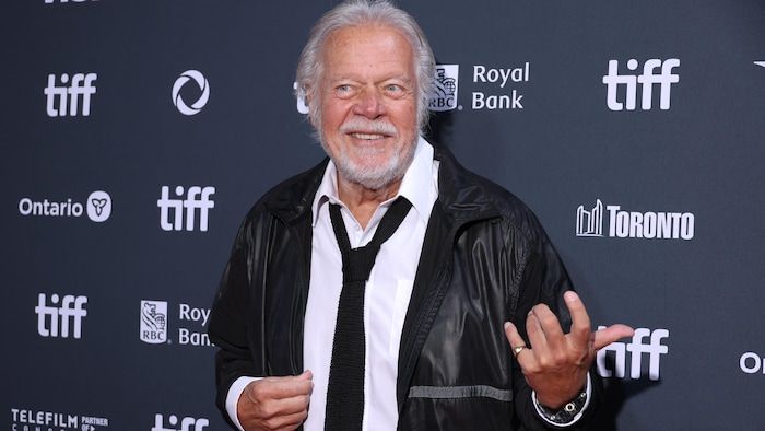 Le musicien sourit sur le tapis rouge.