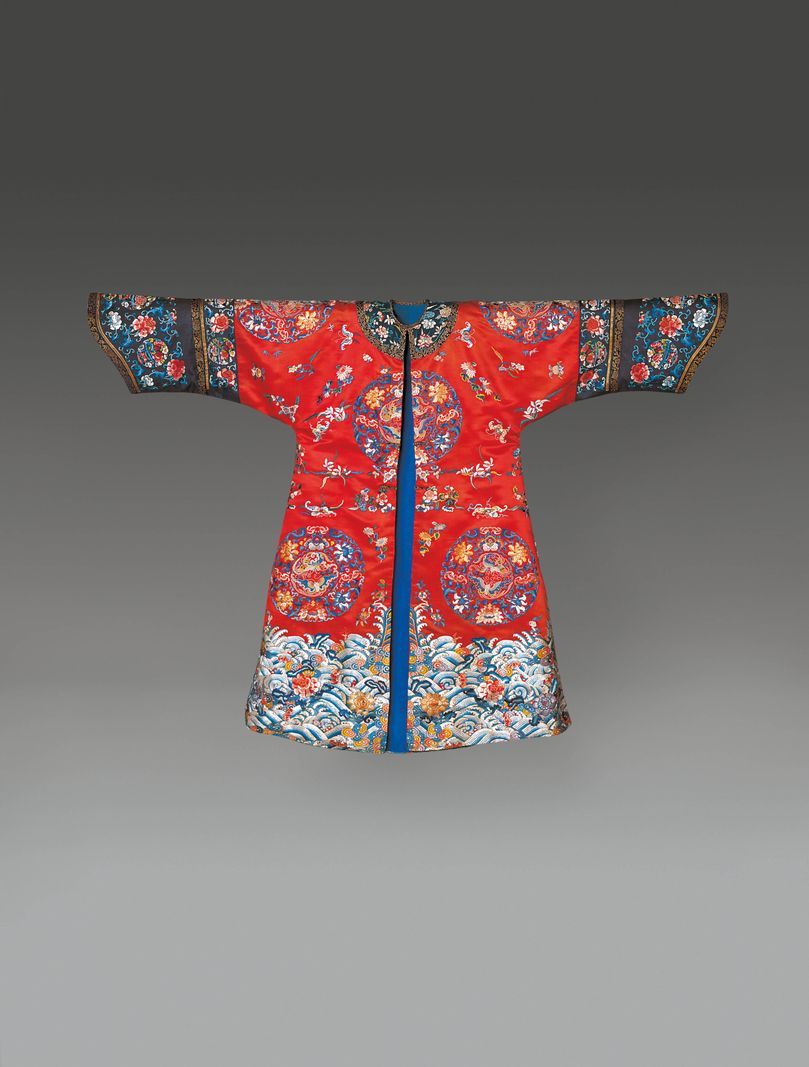 Robe asiatique rouge traditionnelle décorée de motifs colorés et de broderie détaillée. Robe asiatique rouge traditionnelle décorée de motifs colorés et de broderie détaillée.