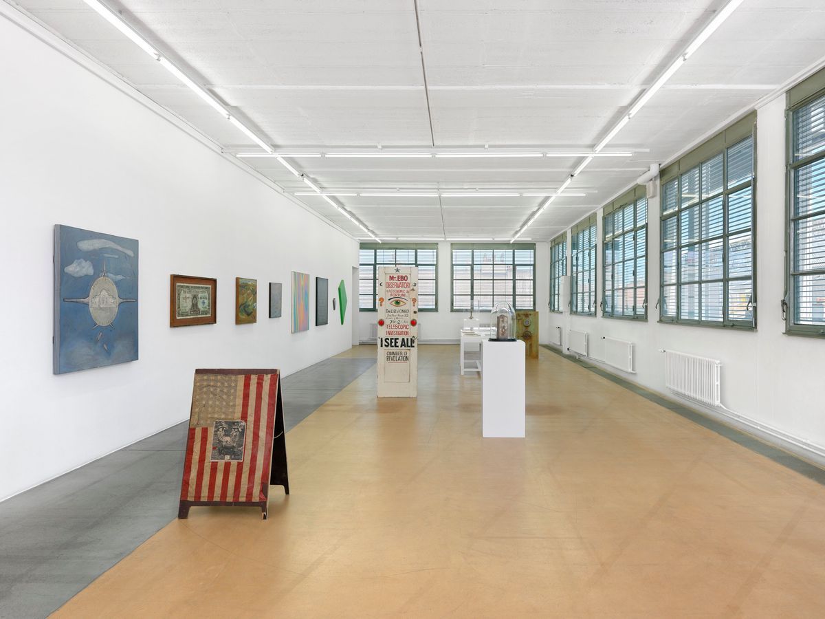 Une galerie d'art moderne avec des peintures et des sculptures exposées sur les murs et le sol. Une galerie d'art moderne avec des peintures et des sculptures exposées sur les murs et le sol.